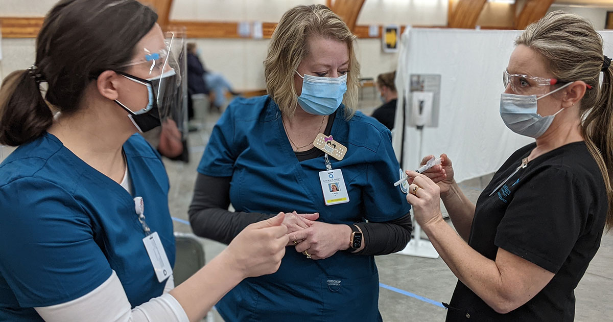 Anoka-Ramsey Nursing instructor, Kristen Bebeau (right) showing students how to administer the vaccine